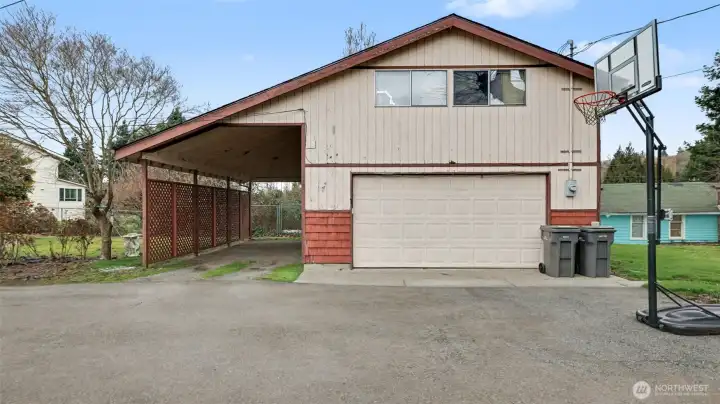 Detached garage features MIL apartment on upper level and covered RV parking.