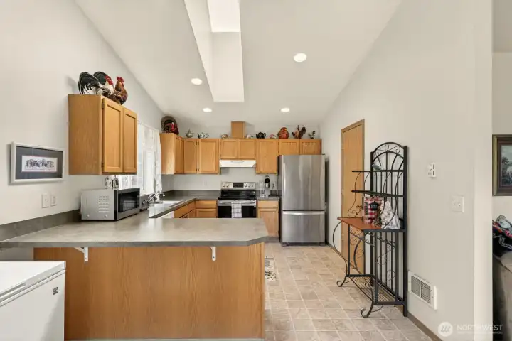 So much natural light in kitchen with skylights and large windows surrounding.