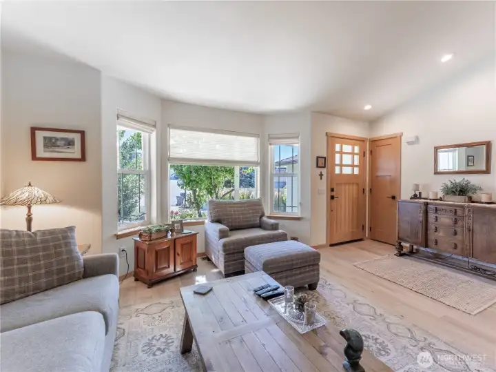 Spacious living room with updated flooring, fresh paint, and abundant natural light creates an inviting gathering space.