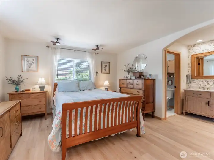 Primary suite offers privacy and comfort with updated flooring and spacious layout.