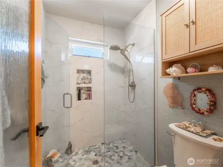 Custom tile walk-in shower with frameless glass door creates spa-like luxury.