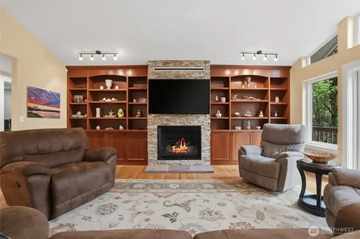 Gorgeous cherry built-in cabinets are just right for displaying photos or other special items, and there is plenty of storage below the shelving. Warm oak flooring adds to the special features of this room.