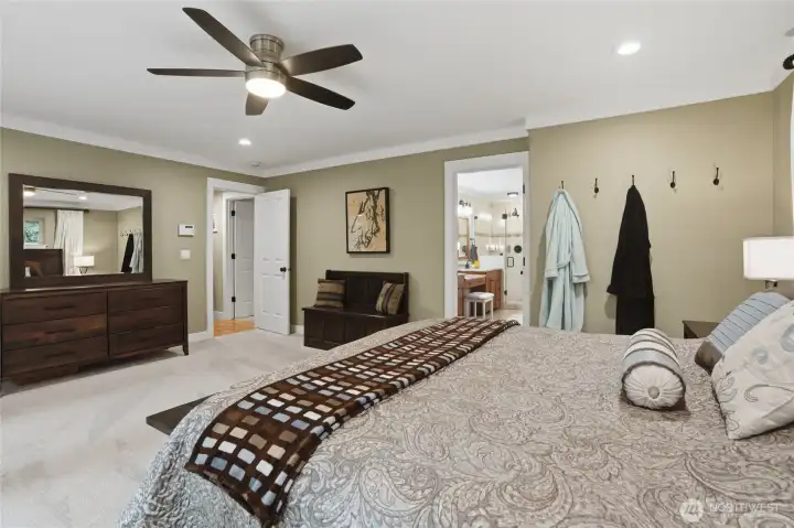 A bedroom ceiling fan in the primary suite is perfect for warmer nights. Being tucked in the trees keeps the  temperature cool in this home on warm summer days.