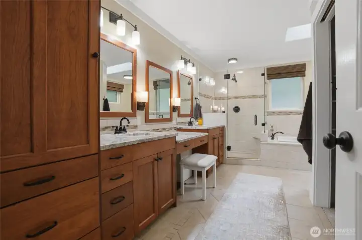 The primary bath includes the same beautiful cherry cabinetry as the rest of the main level, granite counters, double sinks, a vanity area, large walk-in shower, a walk-in closet, and a jetted tub to relax in after a long day.
