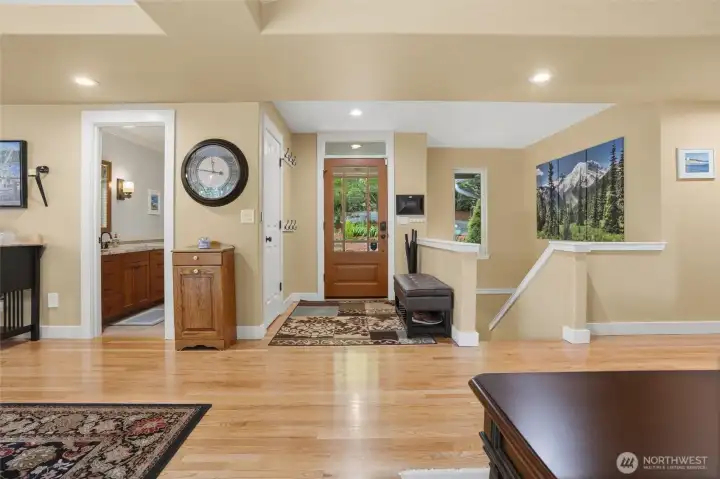A view towards the front entry door with guest bath to the left and stairs leading to the lower level to the right.