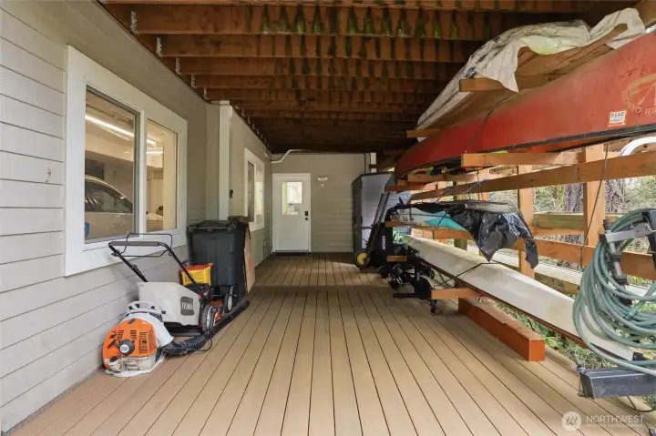 A covered area to the right of the garage allows for storage of yard tools and recreational items.