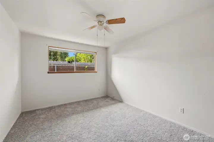 The primary bedroom is larger and looks out to the side yard.