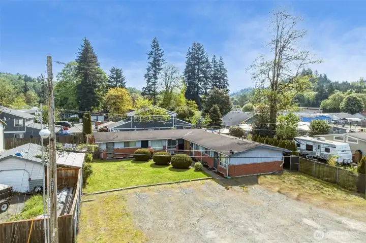 Aerial view showing the property side and large parking area.