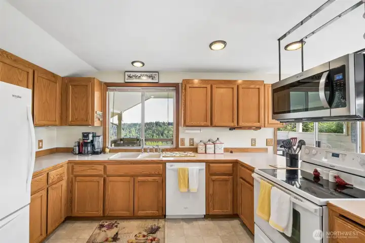 The kitchen features a thoughtfully placed window framing a private territorial view, bringing in natural light while offering a peaceful backdrop. The kitchen features a thoughtfully placed window framing a private territorial view, bringing in natural light while offering a peaceful backdrop.