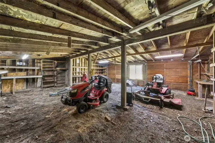 Large garage/barn area with plenty of room for storage- behind the lawn mowers you will notice the two wooden garage doors. Large garage/barn area with plenty of room for storage- behind the lawn mowers you will notice the two wooden garage doors.