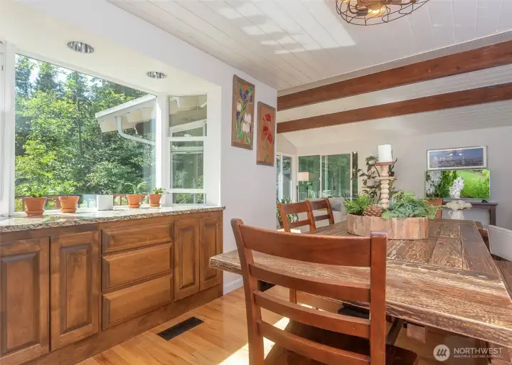A fabulous built-in banquette surrounded by expansive windows creates the perfect gathering space, offering abundant natural light and beautiful views of the private backyard.