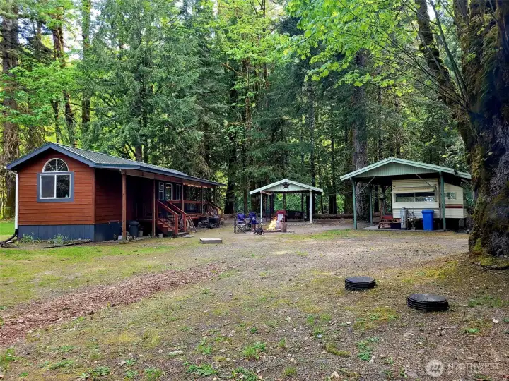 home, picnic shelter, fire pit, and covered travel trailer