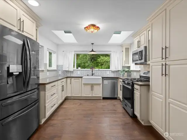 This gourmet kitchen features elegant quartz counters, an apron front sink, and stainless steel appliances.