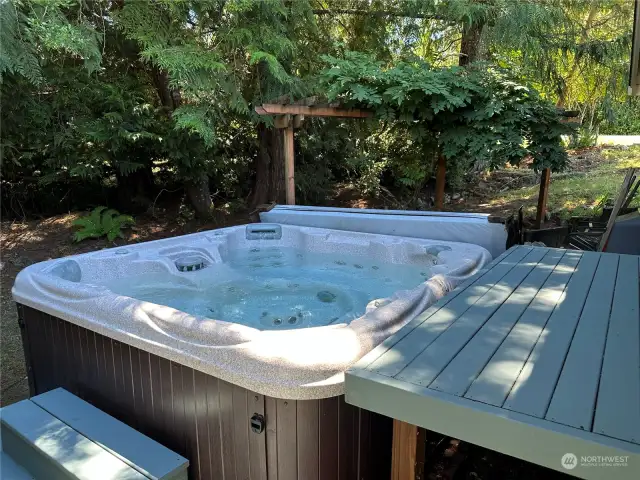Located behind the garage in a peaceful nook is the hot tub
