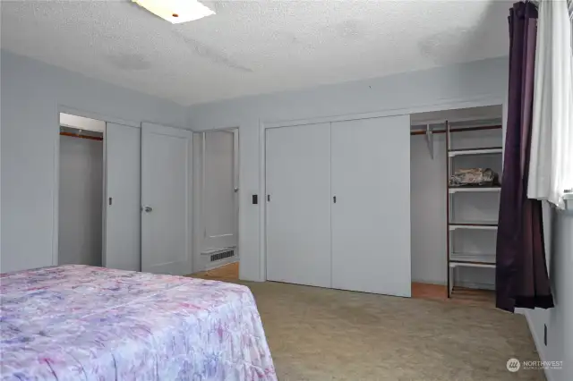 Primary bedroom offers two separate closet. The smaller closet on the left has shelving on each end. The larger closet has a window A/C unit hidden behind the door. All A/C units in the home are to stay with the property.