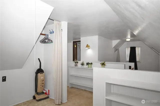 This half of the upstairs has nearly mirrored spaces with shelving and closet space on each side. Each side also has it's own door leading to additional attic space for storage.