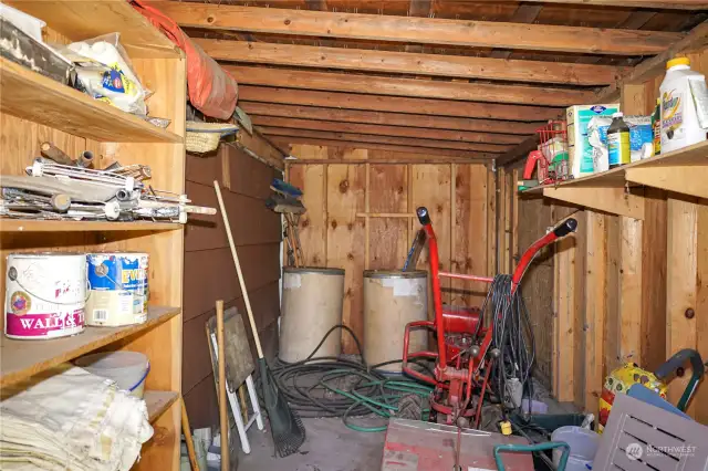 On the opposite side of the shop room is a shelved shed space.