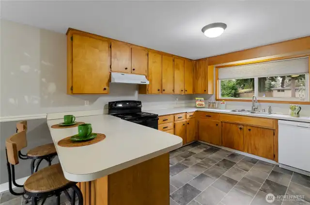 Spacious kitchen with large eating space, breakfast bar, lots of storage, beautiful flooring.