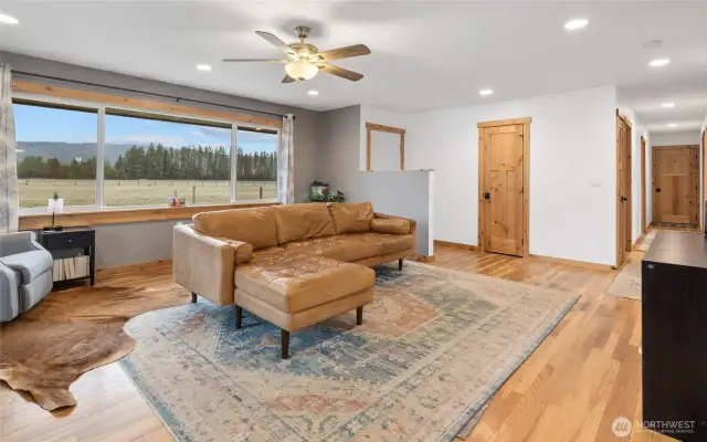 The living space showcases the original hardwood floors & picture windows for tons of natural light. You'll notice the extra coat closet & access to the back deck here.