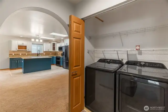 Utility area with washer and dryer behind bifold doors. Notice the coved doorways.