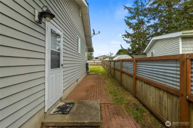 Brick walk way down the side of home for those wet winters. Door enters here to garage.