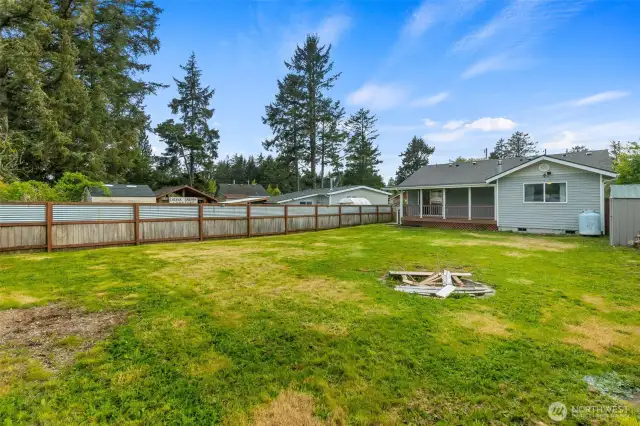 View of backyard and back of home. Firepit in the center of backyard for summer evenings. Propane tank is owned and goes with the home