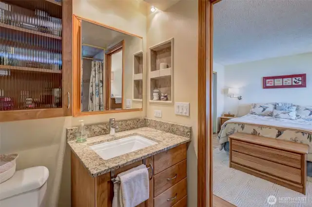 Primary bath has granite counter, custom cabinetry, upscale fixtures, and a POCKET DOOR!