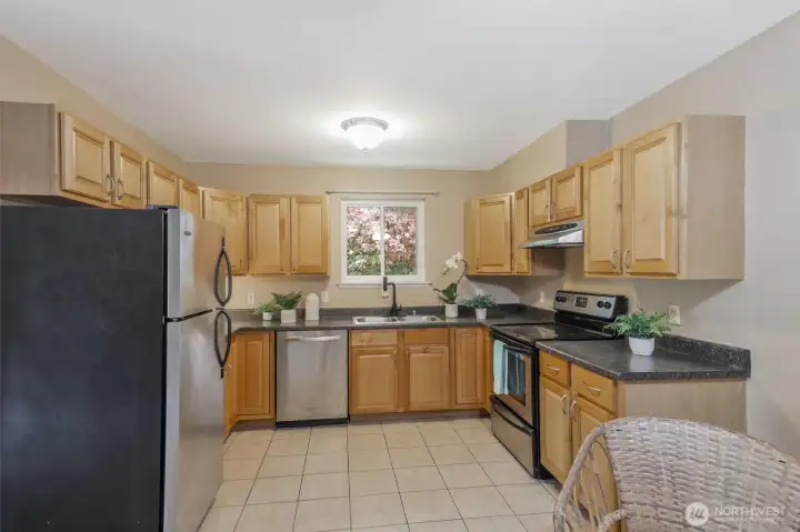 The kitchen is spacious with plenty of cabinets and room for more than one person to move around.