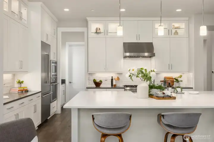 Beyond refrigerator is a work area and a spacious pantry behind the door