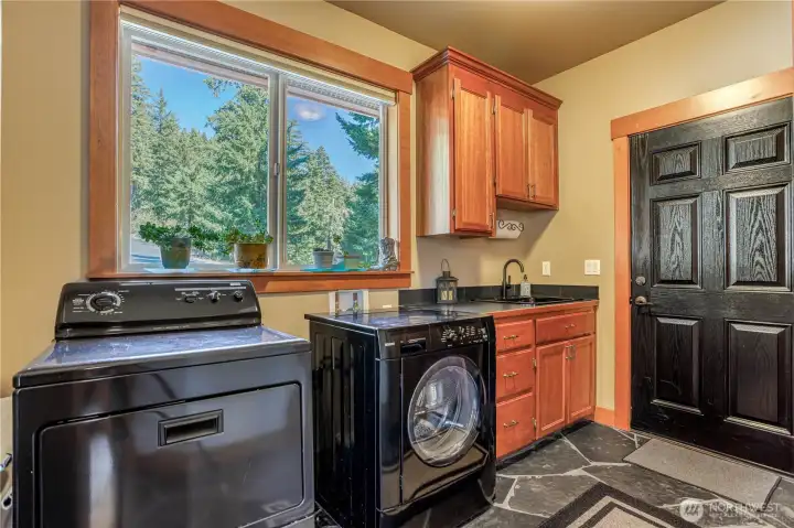 Laundry room entry off the side deck makes it easy to load groceries into the kitchen or clean up easily at the utility sink. View to the driveway side & plenty of storage.