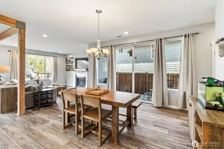 Open dining area flowing seamlessly into the living room with abundant natural light and access to outdoor space.