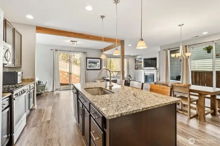 Open kitchen with oversized island flowing seamlessly into dining and living areas.