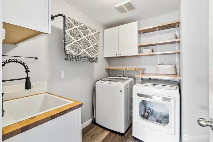 Laundry room with built-in shelving and utility sink.