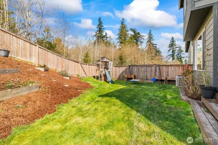 Backyard with space for entertaining, play, or gardening.