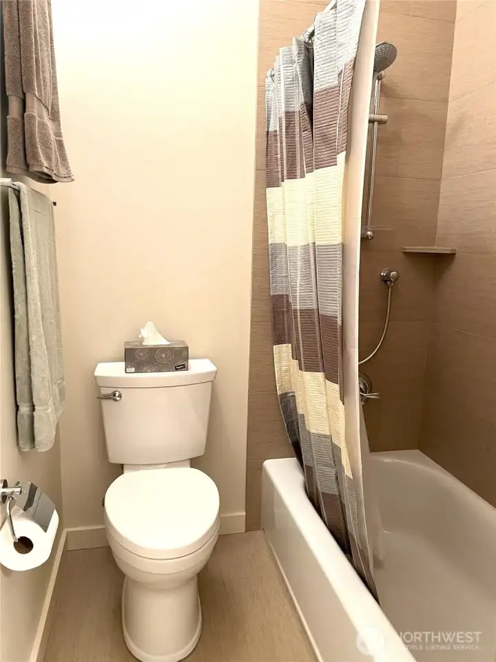 Full bath has tile on the floors and tub surround.