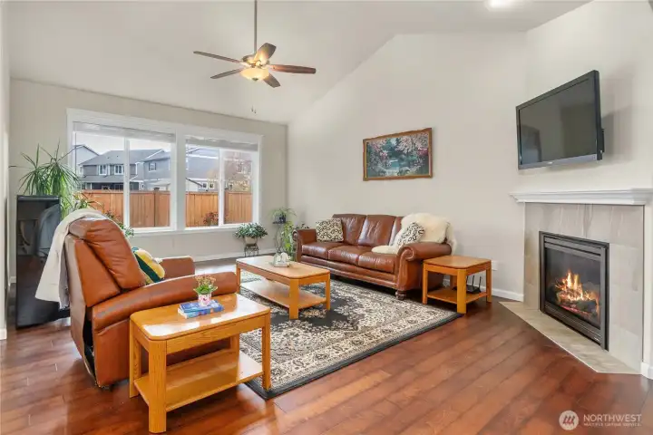 Warm and inviting great room features vaulted ceilings & a cozy gas fireplace with tile surround.
