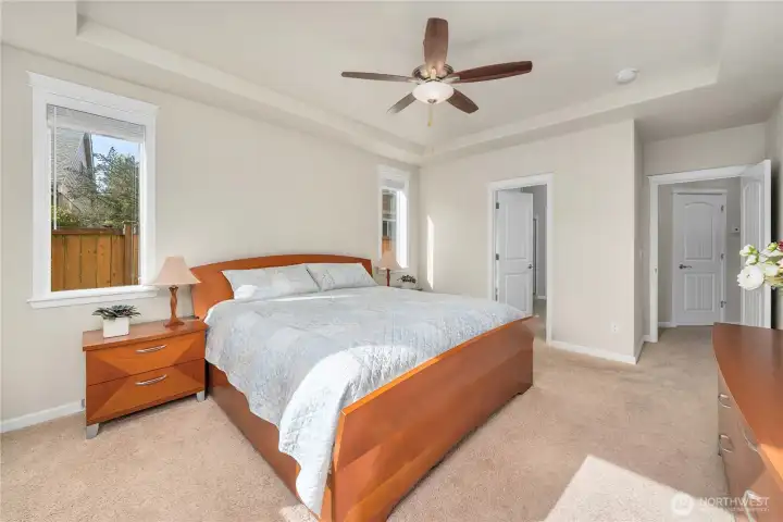 Primary suite offers abundant natural light, coffered ceiling, walk-in closet & full bathroom.