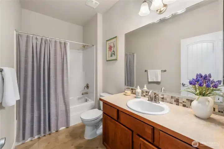 Main-level full bathroom with a shower-tub combo, ideally positioned next to the second bedroom for added convenience.