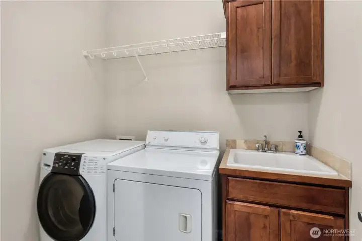 Dedicated laundry room with washer/dryer, utility sink, and added storage