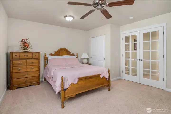 Fourth bedroom upstairs with French doors—ideal as a guest room, office, or flexible living space.