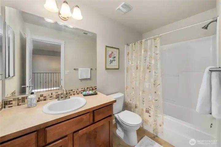 Full upstairs bathroom with shower-tub combo and ample counter space for everyday use.