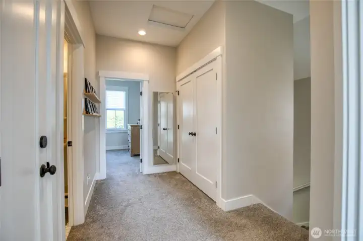 Up the stairs is a large hallway that leads to two bedrooms, a primary suite, a full bath and laundry closet.