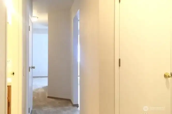 Unit B main level hallway with half bath and laundry on the left
