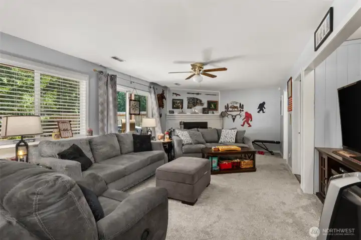 Lower level family room with wood fireplace, sliding doors to patio and half bath