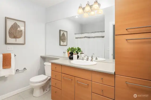 This full bathroom offers tile flooring and tons of cabinet space.