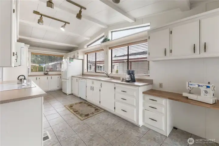 Natural light and vaulted ceilings are a feature in this functional kitchen with space for your crafts / hobbies or even a small home office. Look at all that storage space