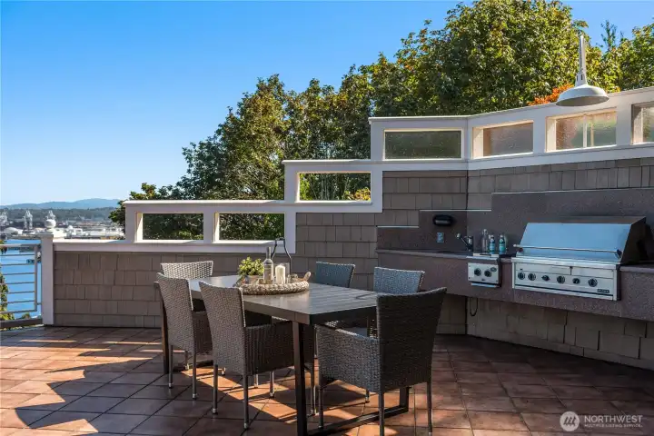 An outdoor kitchen is complete with a sink, grill and griddle.