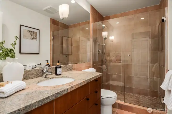 This private bath boasts extensive tile work and is a part of the lower bedroom suite.