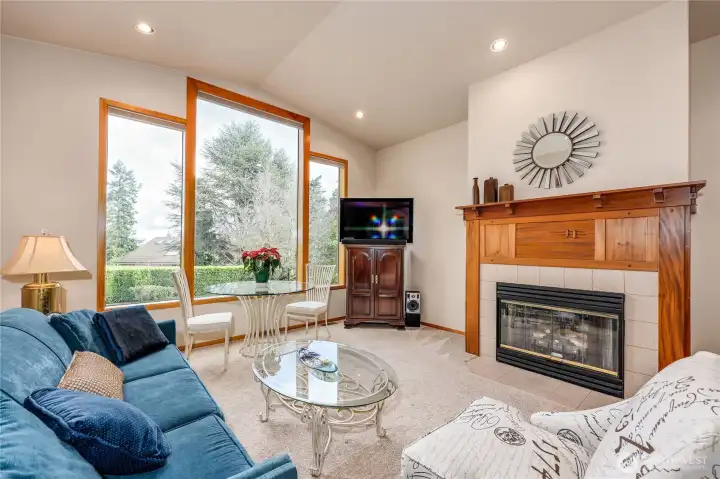 The living room features a propane fireplace and wall of windows.