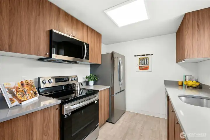 Kitchen with Stainless steel appliances, quartz countertops, smooth top electric range